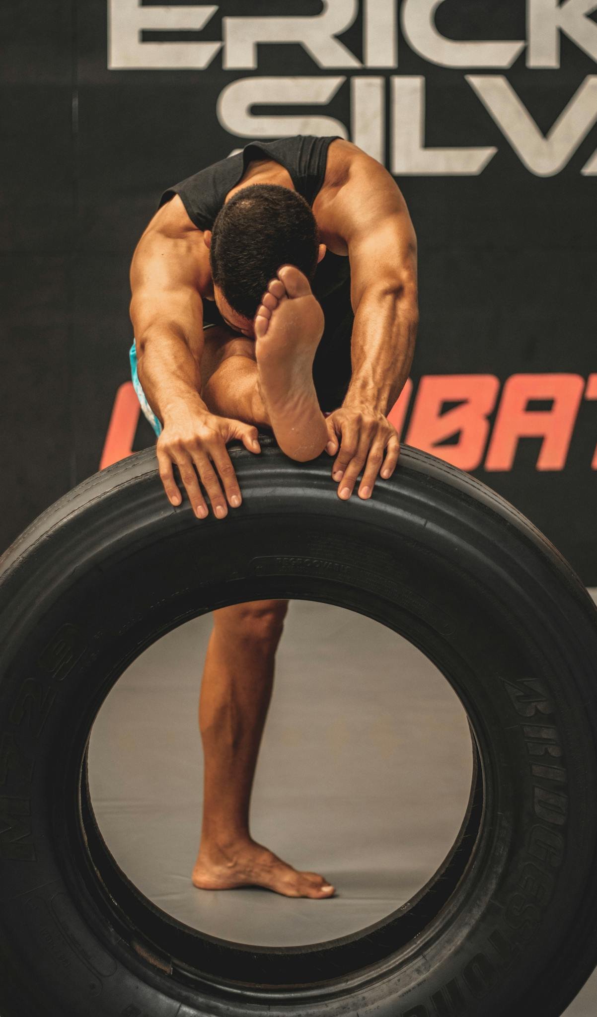 Anonymous barefooted sportsman warming up before training